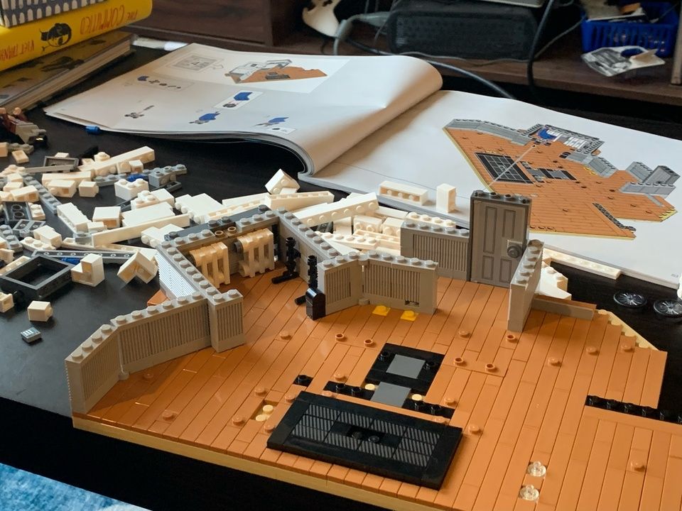 Jerry Seinfeld's apartment, partway build with Lego. An open Lego manual lays on the coffee table behind the construction, with a mess of Lego pieces to the left.